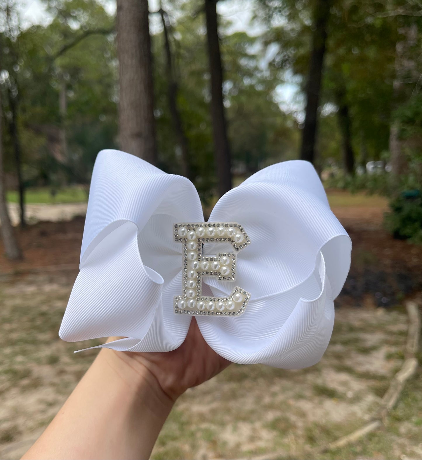 White ribbon bow with letter emblem