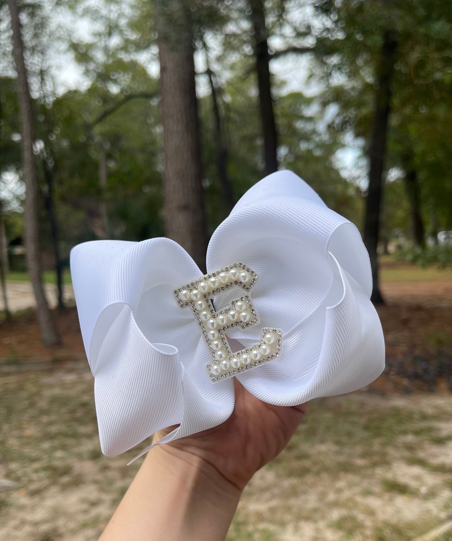 White ribbon bow with letter emblem